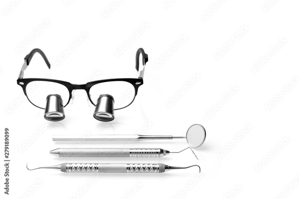 Dentist surgical loupes and different dental tools isolated on white
