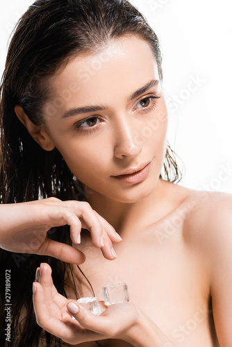beautiful wet nude young woman holding ice cubes and looking away isolated on white