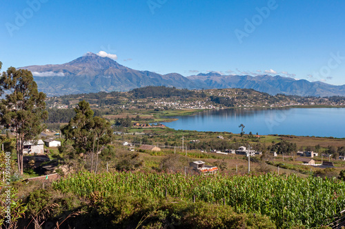Beautiful view of the San Pablo lake, with surrounding houses and towns, and the Cotacachi volcano in the background, on sunny and bright morning. Ecuador South America