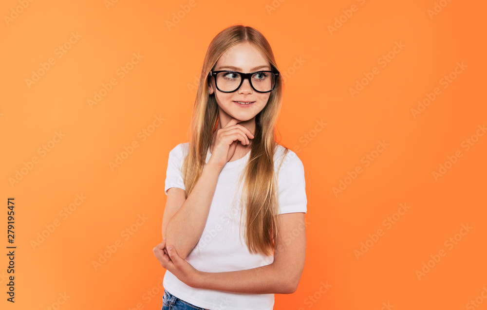 Close up portrait of happy, funny and beautiful blonde little girl in glasses is posing over yellow background. Study, education, school, university, college, graduate concept.