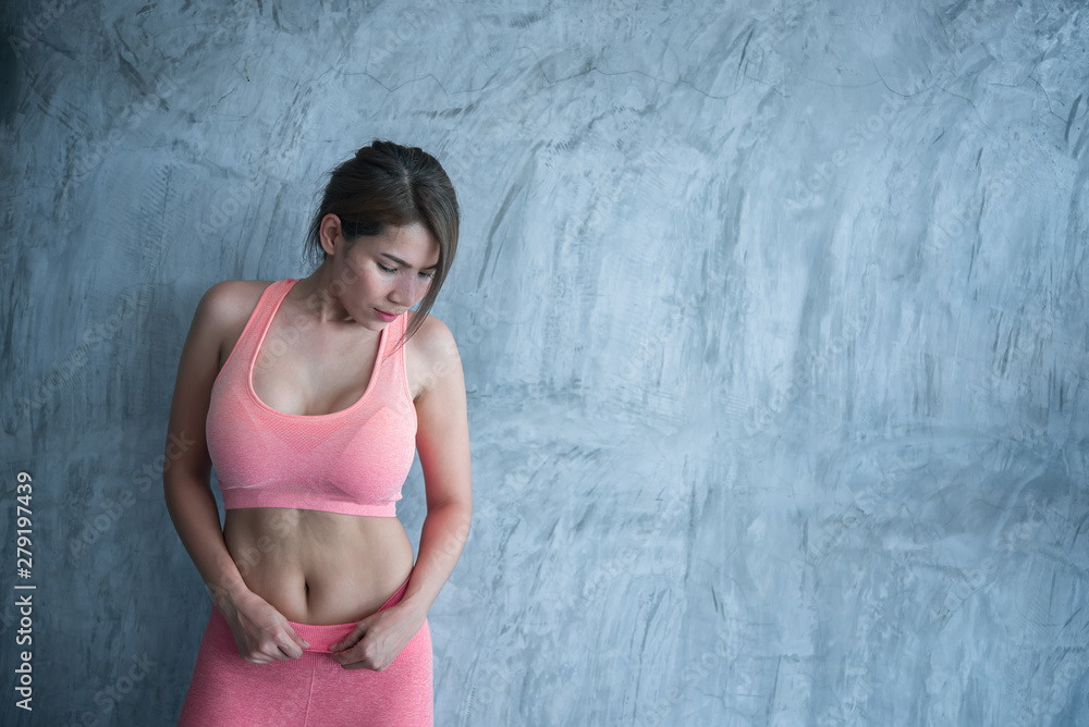Close up asian beautiful sport girl on wall of gym,Thailand love health,Slim woman workout concept Close up asian beautiful sport girl on wall of gym,Thailand love health,Slim woman workout concept