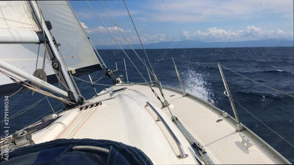 Front bow of a sailboat open sails in the sea waves Front bow of a sailboat open sails in the sea waves