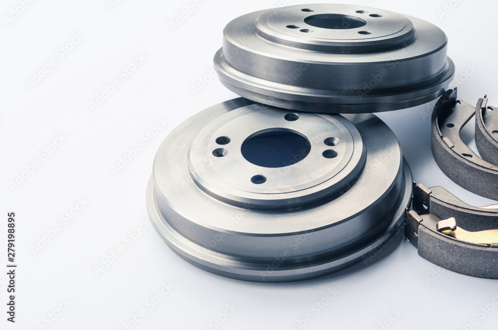 New auto parts brake drums, pads, cylinders on white background New auto parts brake drums, pads, cylinders on white background