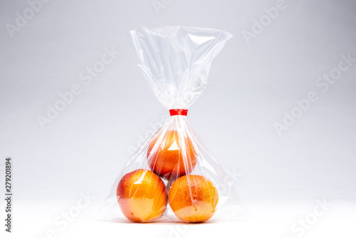 Three oranges  in a plastic bag