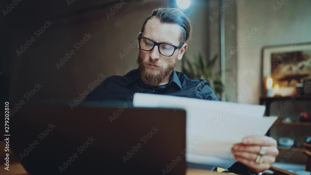 Bearded businessman man working at sunny office on desktop computer while sitting at wooden table. Bearded businessman man working at sunny office on desktop computer while sitting at wooden table.