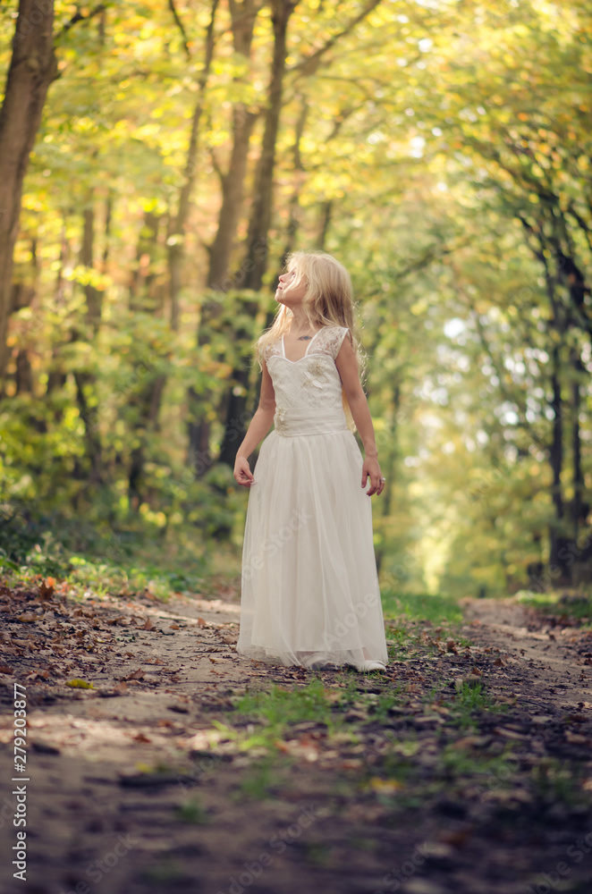 adorable blond girl walking in sunny day in magical forest adorable blond girl walking in sunny day in magical forest