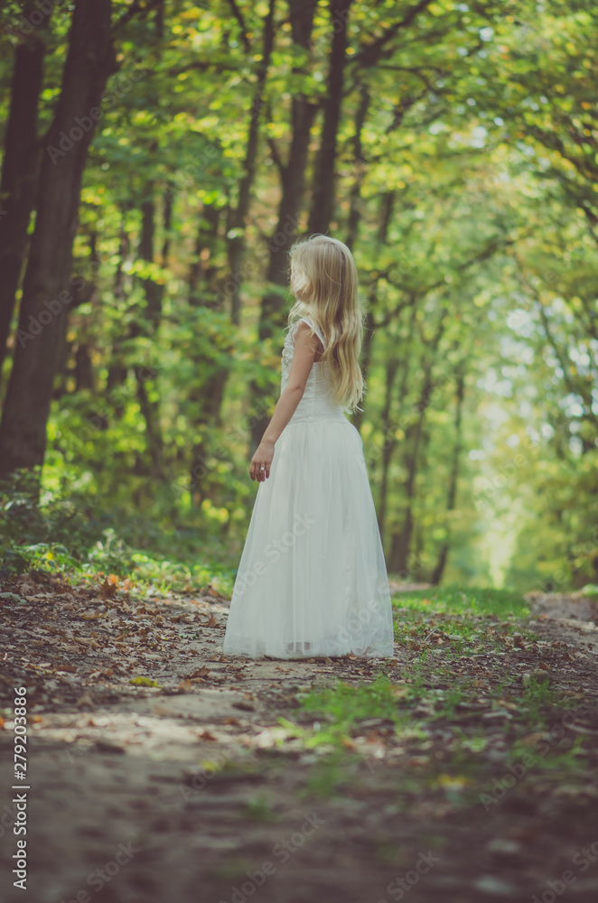 adorable blond girl walking in sunny day in magical forest adorable blond girl walking in sunny day in magical forest