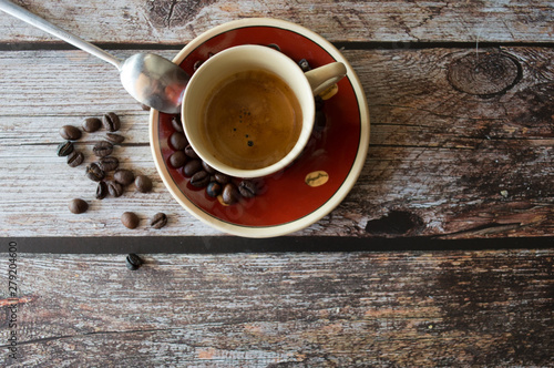 Tazza di caffè con grani sparsi sul tavolo di legno 