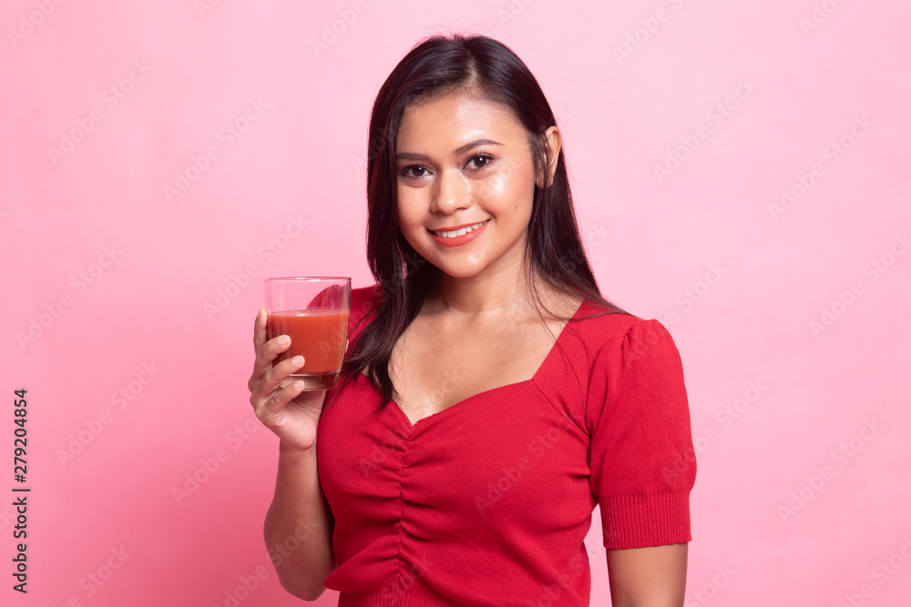 Young Asian woman drink tomato juice.