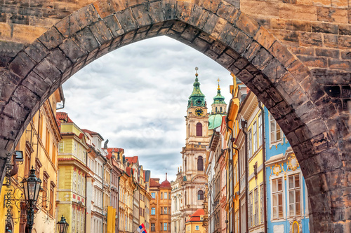 View of old town with facades of colorful old buildings through the arch of the Malostransky tower of Charles Bridge in Prague, Czech Republic photo