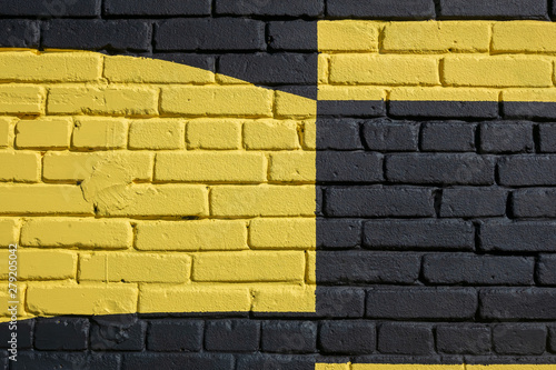 Brick wall painted in yellow and black