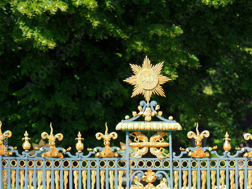 Fragment of the fence of Charlottenburg Palace, Berlin, Germany. Schloss Charlottenburg. Green garden, linden trees photo