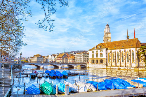 View of historic Zurich city center with famous Grossmunster Church and port with boats on the quay of the river Limmat, Canton of Zurich, Switzerland © MarinadeArt