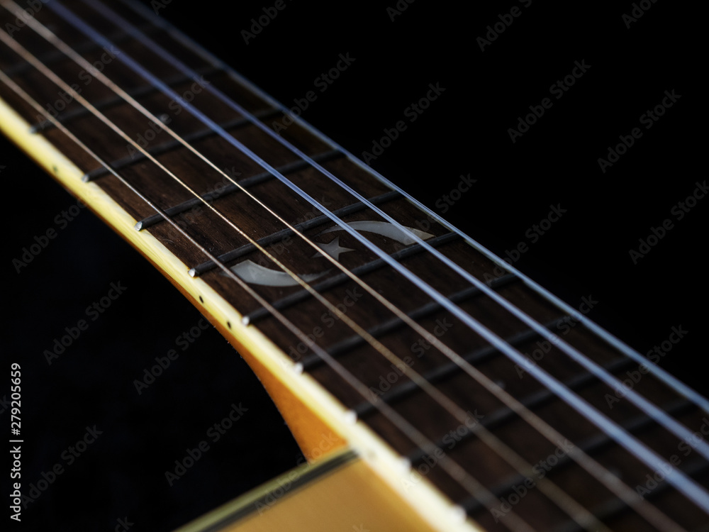 Fototapeta premium six - string acoustic guitar on a black background. low key. music day