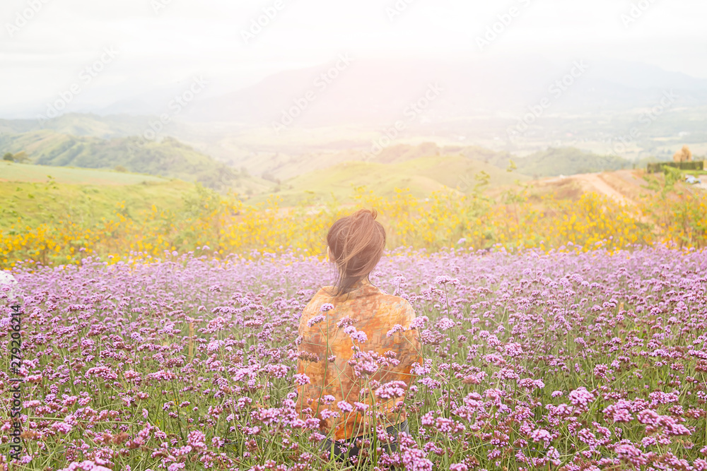 Fototapeta premium Asian tourists are standing to admire the beauty of flowers in the mountain gardens at Phetchabun province , Thailand.Travel with family cancept.