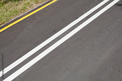 Asphalt road with yellow and white lines background © heshixin