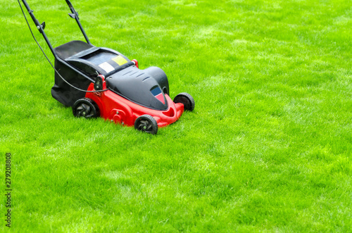 red lawn mower on green grass