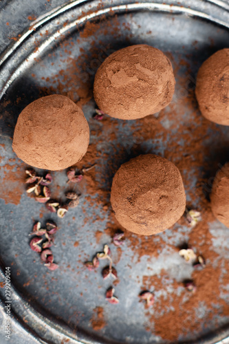 delicious dark chocolate candy truffles with sichuan pepper on dark background, top view