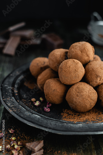 dark chocolate candy truffles with sichuan pepper on dark background