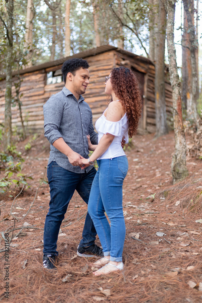 couple in love watching each other surrounded by trees in the forest couple in love watching each other surrounded by trees in the forest