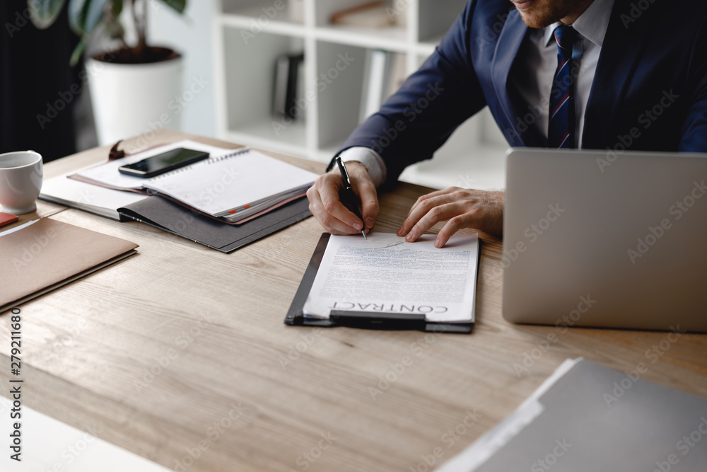 Person sitting at the table and signing important contract Person sitting at the table and signing important contract
