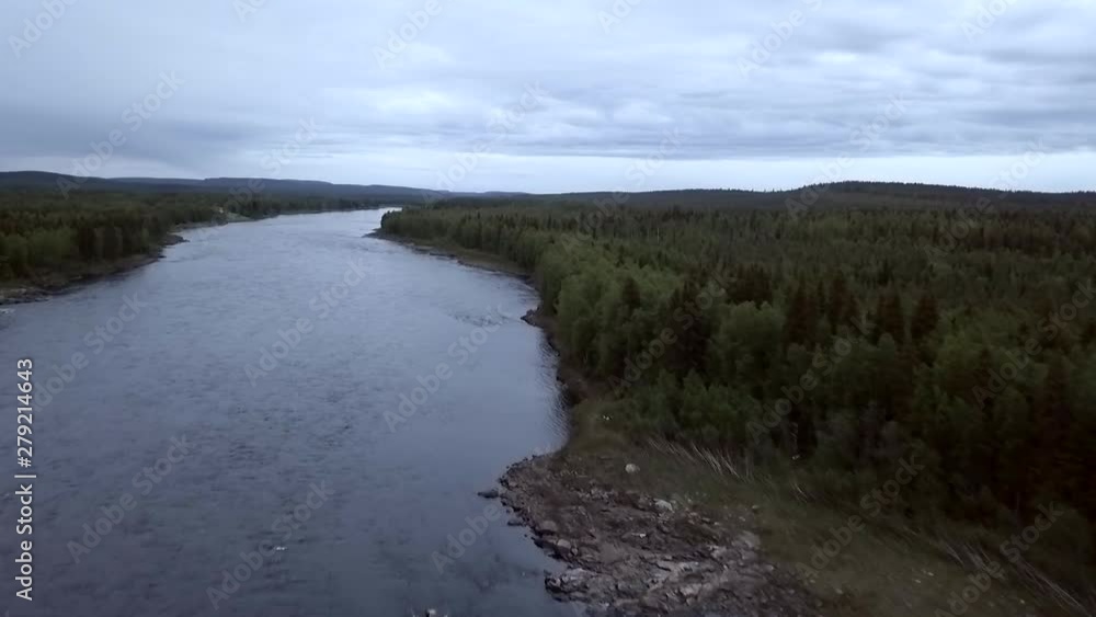 Aerial, rising, drone shot, over rocky coast and forest, at Tornionjoki river , on a cloudy evening, in Pello, Lapland, Finland Aerial, rising, drone shot, over rocky coast and forest, at Tornionjoki river , on a cloudy evening, in Pello, Lapland, Finland