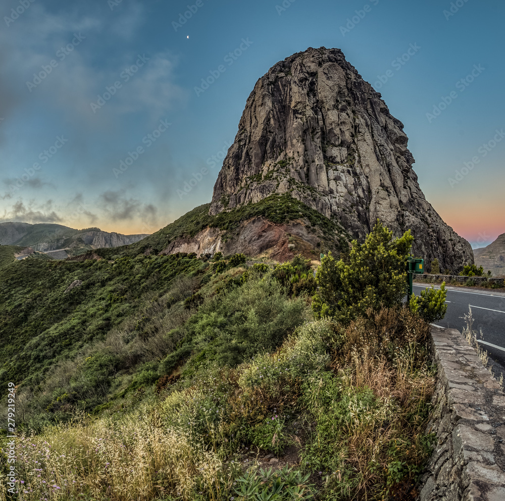 Los roques and famous Agando rock - cult place near Garajonay national park at La Gomera. Old volcanic mountain peaks. Thickets of relic laurels and heather on steep green slopes. Canary. Spain Los roques and famous Agando rock - cult place near Garajonay national park at La Gomera. Old volcanic mountain peaks. Thickets of relic laurels and heather on steep green slopes. Canary. Spain