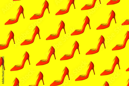 Female red shoes pattern on yellow background, isolated. Party, Valentine's Day, Christmas, Happy New Year, Black Friday, sale, wedding outfit conception. Flat lay, top view, copy space.