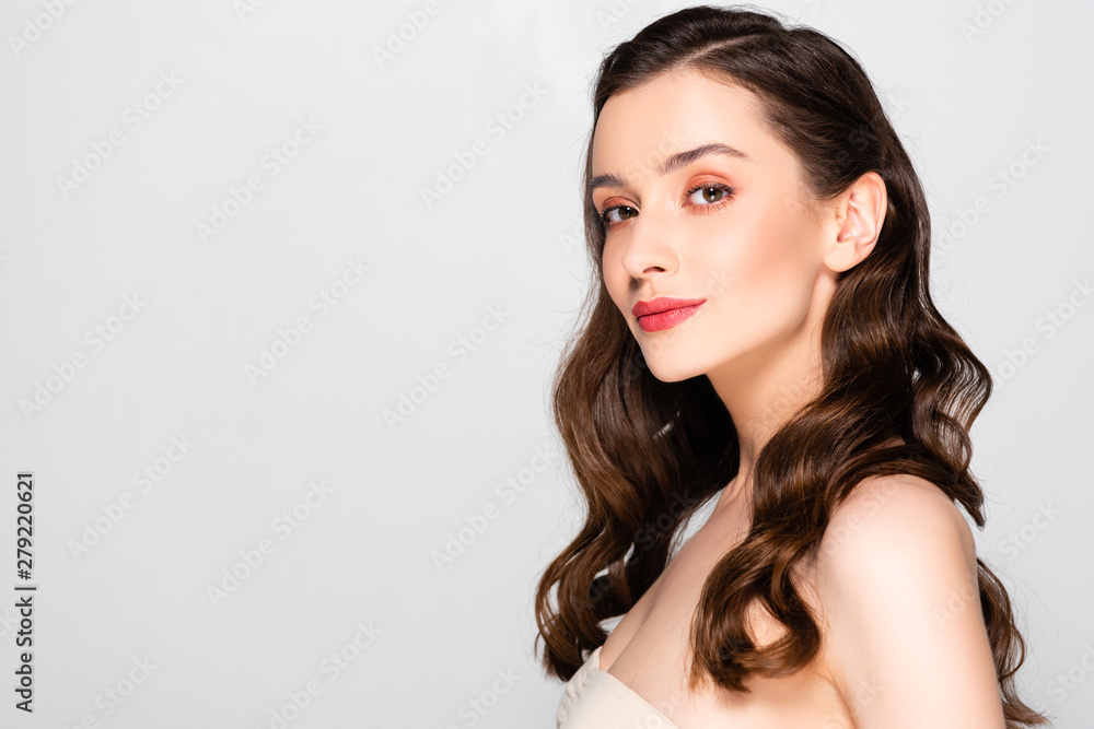 side view of beautiful brunette woman with curls and makeup isolated on grey side view of beautiful brunette woman with curls and makeup isolated on grey