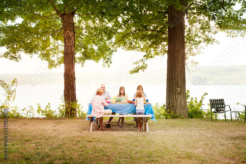 Fényképezés Family with kids dining at picnic table