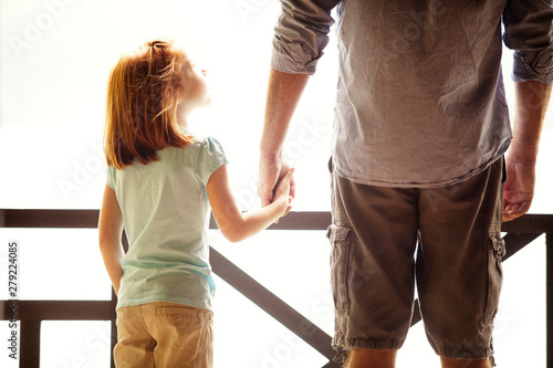 Fotografija Father and daughter (6-7) holding hands on porch