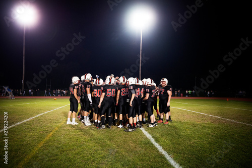 Foto Football players (14-15, 16-17) on playing field ay night