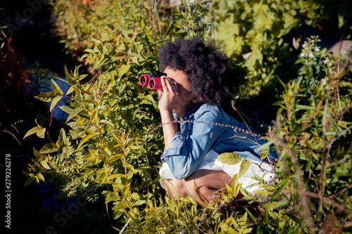 Girl (8-9) looking through binoculars
