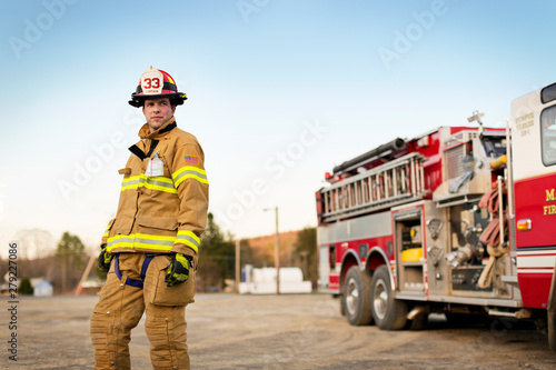 Firefighter standing in front of fire engine