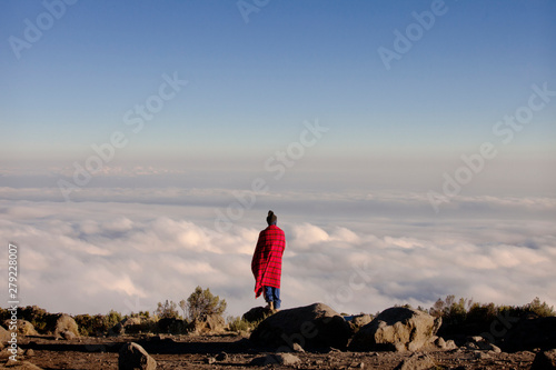 Fotografía Rear view of man standing on rock and looking at view