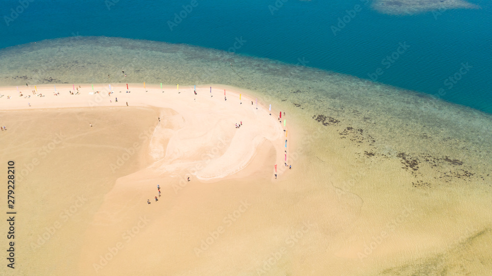 White sand beach in Honda Bay, view from above. White beach with colorful flags and tourists. Island hopping Tour at Honda Bay, Palawan.