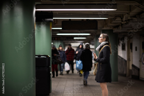 Canvas Print Side view of young woman standing at subway station
