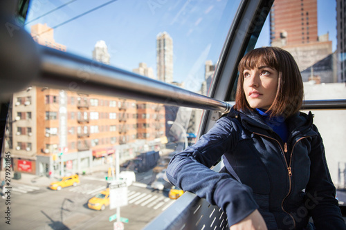 Canvas Print Young woman looking through window while travelling by subway train