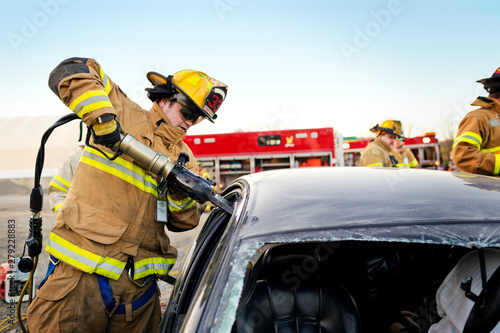 Firefighters tending damaged car at accident site