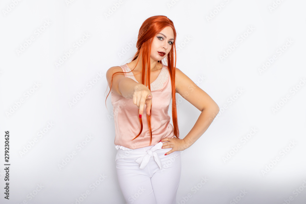 Studio portrait of a red-haired woman with long hair. Business clothes - white pants and light pink blouse with pearls Studio portrait of a red-haired woman with long hair. Business clothes - white pants and light pink blouse with pearls