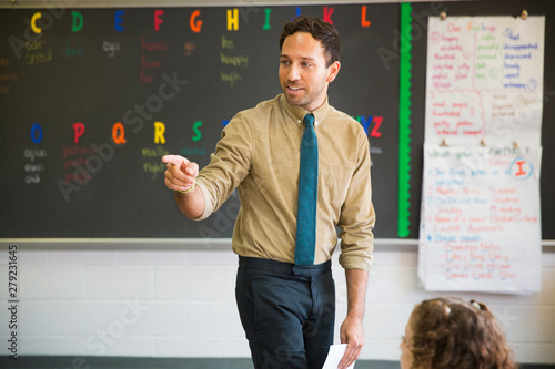 Vászonkép Elementary school teacher standing in classroom