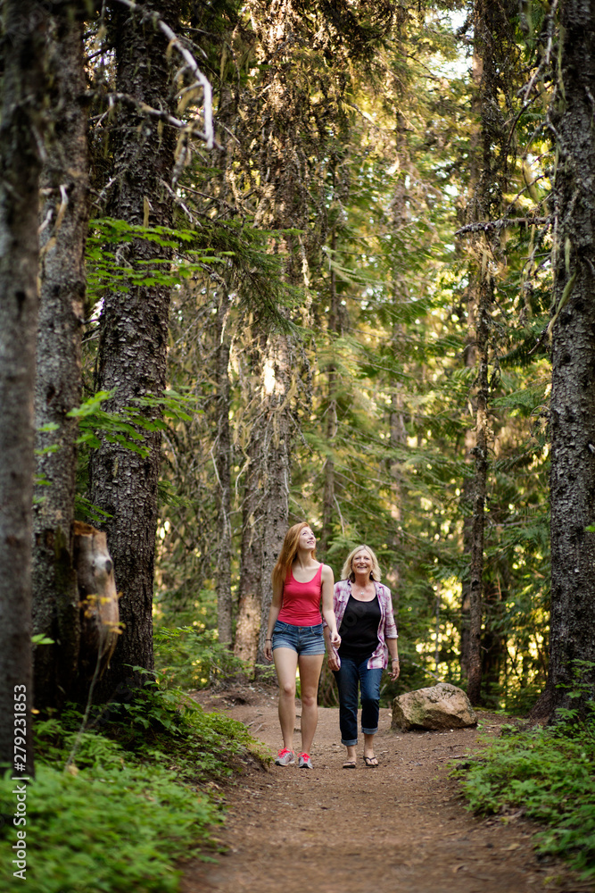 Obraz premium Mother with adult daughter walking in forest