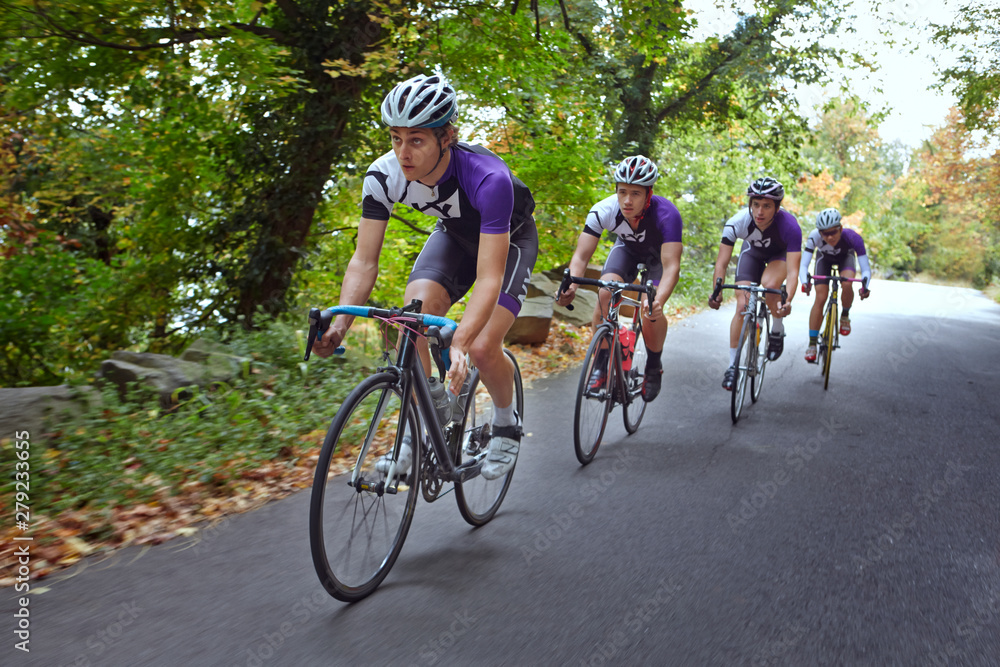 Fototapeta premium Group of cyclists riding down road