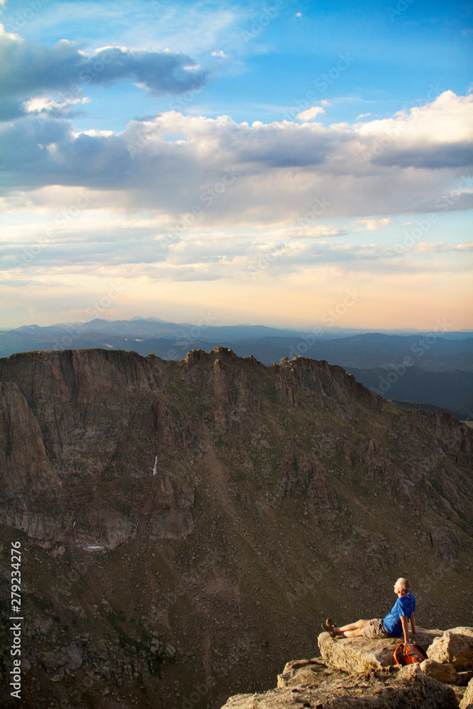Fototapeta premium Mature man on cliff overlooking mountain range