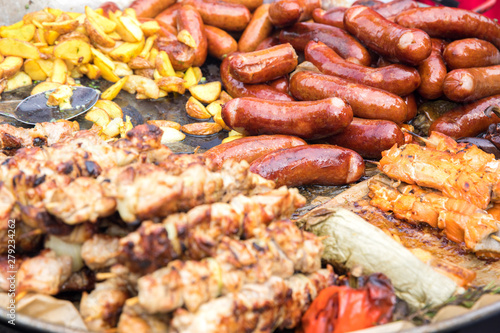 Kebabs of meat, sausages, potatoes in a rustic style fried in a large pan. Close up.