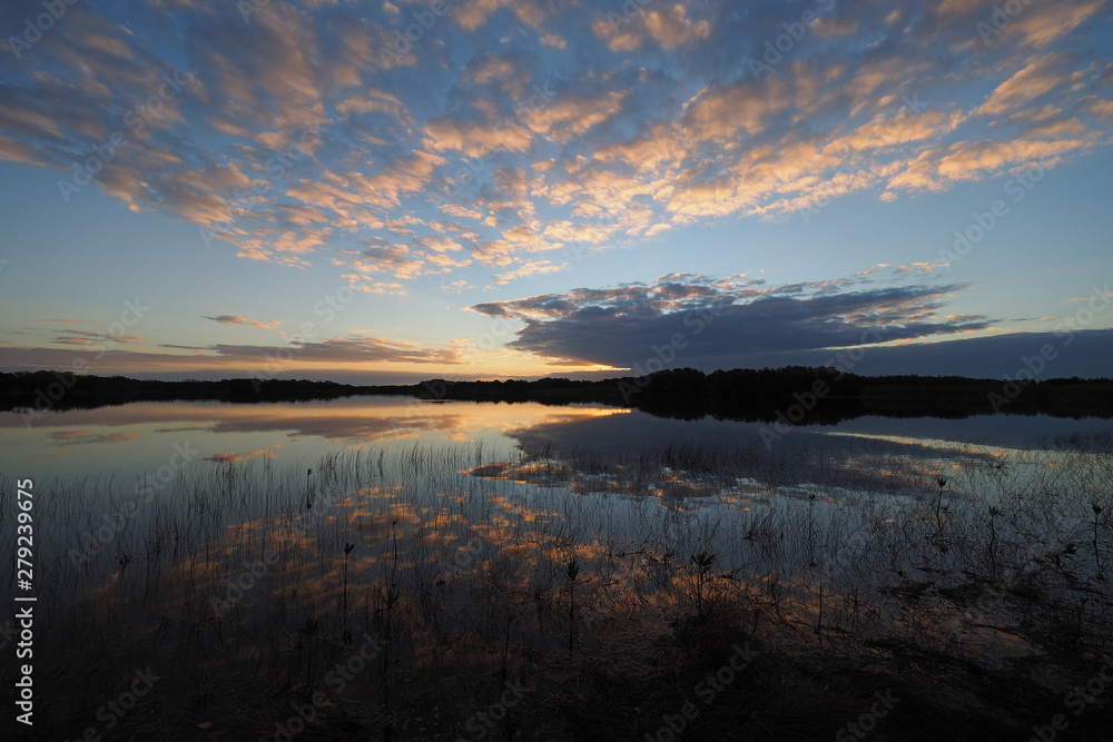 Sunrise and clouds reflected in the calm water of Nine Mile Pond in Everglades National Park, Florida. Sunrise and clouds reflected in the calm water of Nine Mile Pond in Everglades National Park, Florida.