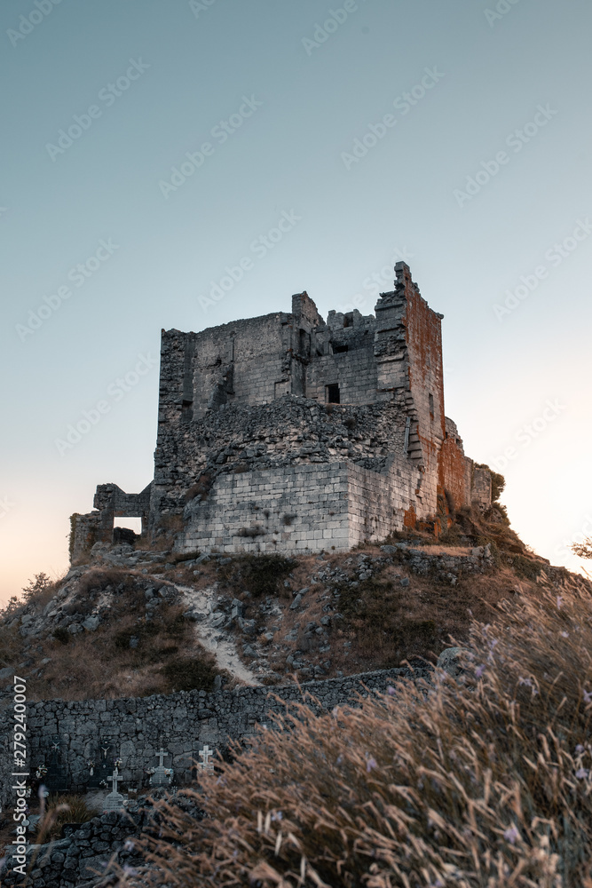 ruined castle at the top of the hill in a sunset