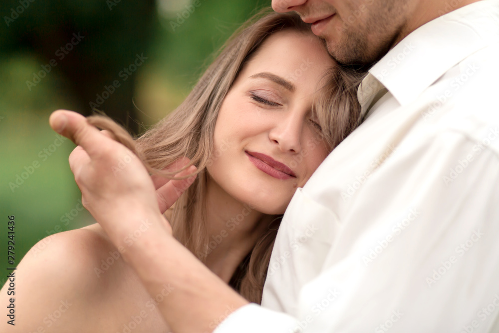 Young loving couple hugging and dancing on the green grass on the lawn. Beautiful and happy woman and man gently touch each other. Beautiful couple in love. girl in the dress and the guy in the shirt Young loving couple hugging and dancing on the green grass on the lawn. Beautiful and happy woman and man gently touch each other. Beautiful couple in love. girl in the dress and the guy in the shirt
