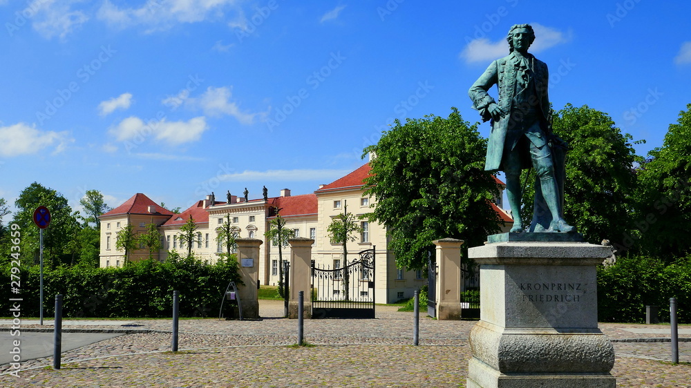 Bronzestatue von Kronprinz Friedrich steht vor dem Schloss Rheinsberg in Mecklenburg