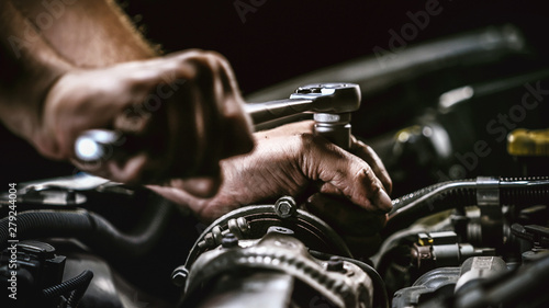 Fotografija Auto mechanic working on car engine in mechanics garage